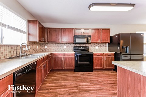a kitchen with wooden cabinets and black appliances