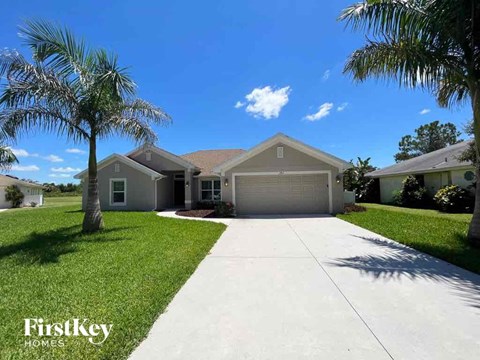 a house with a driveway and palm trees