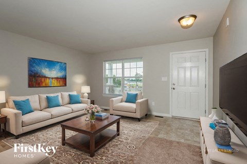 A living room with a couch, a coffee table, and a painting on the wall.
