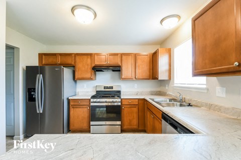 A kitchen with wooden cabinets and a stainless steel refrigerator.