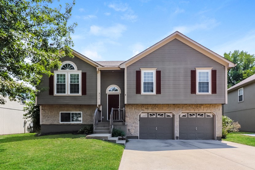 a house with a driveway and two garage doors