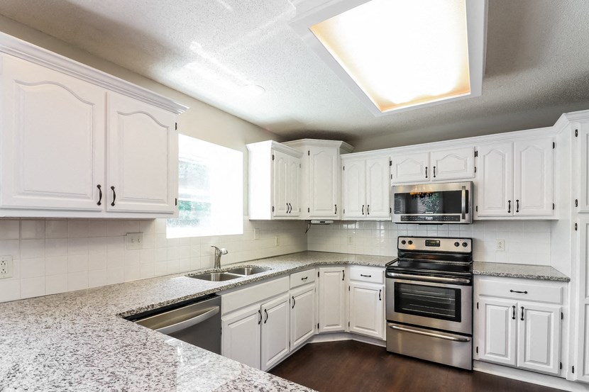 a kitchen with white cabinets and stainless steel appliances