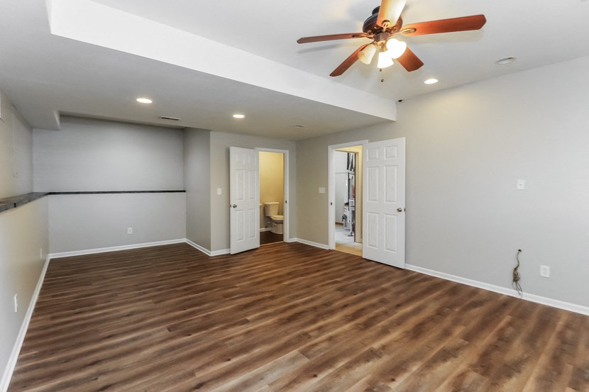 an empty living room with a ceiling fan and wood flooring