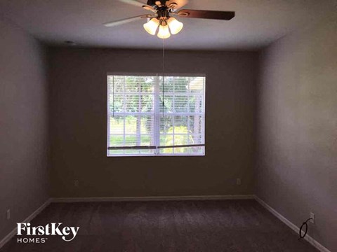 A room with a ceiling fan and a window.