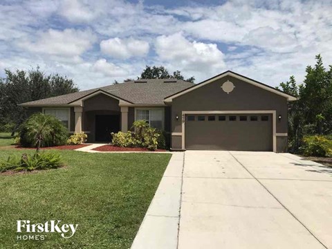 A house with a garage and a driveway in front of it.