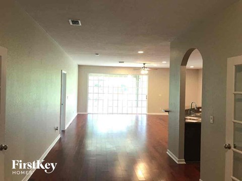 A spacious room with wooden floors and a large window.