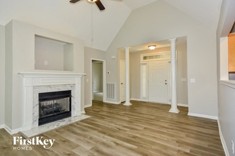 A spacious living room with a fireplace and wooden flooring.