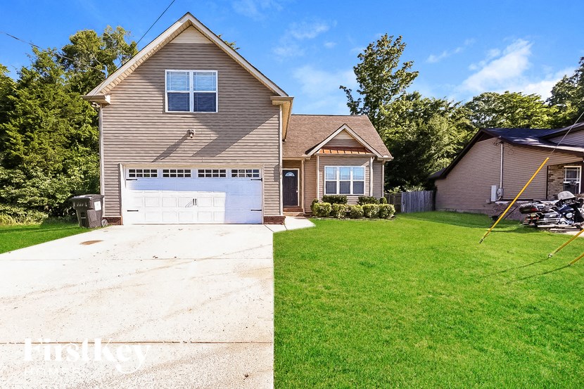 A house with a garage and a driveway in front of it.