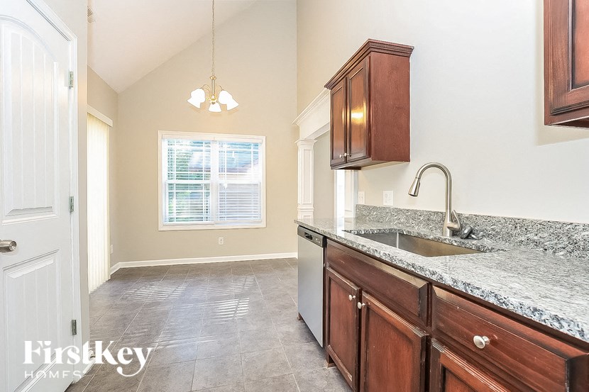 A kitchen with wooden cabinets and a granite countertop.