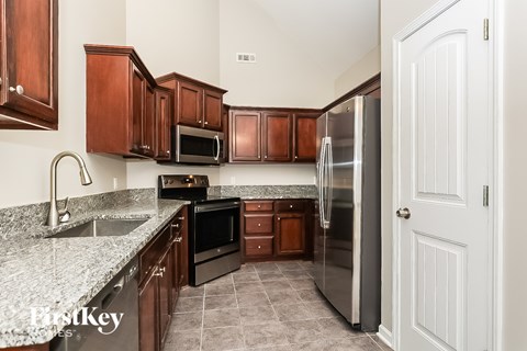A kitchen with wooden cabinets and a stainless steel refrigerator.