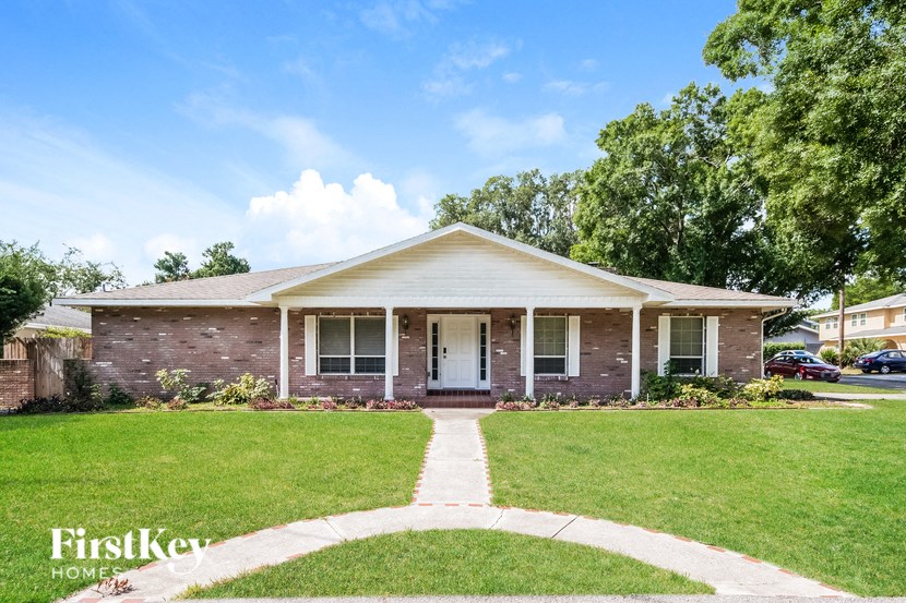 a brick house with a lawn and a sidewalk