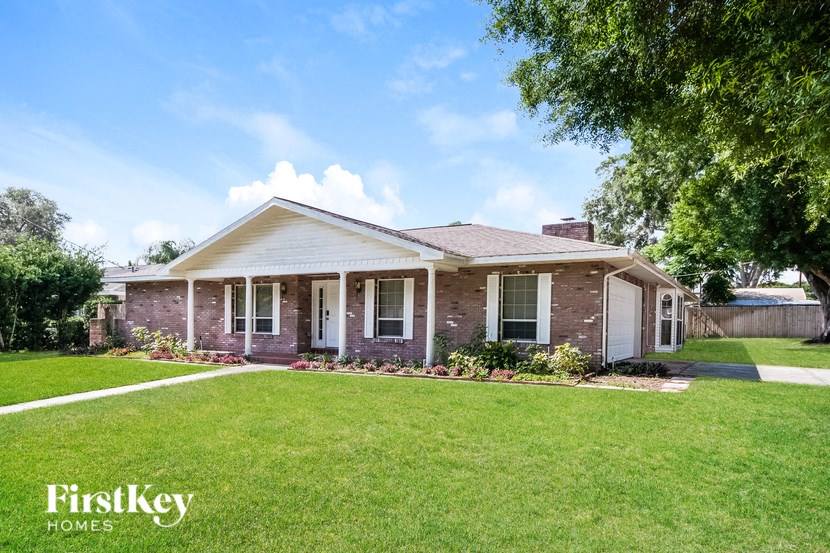 a small brick house with a lawn and a tree