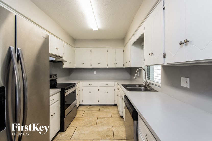 a large kitchen with white cabinets and stainless steel appliances