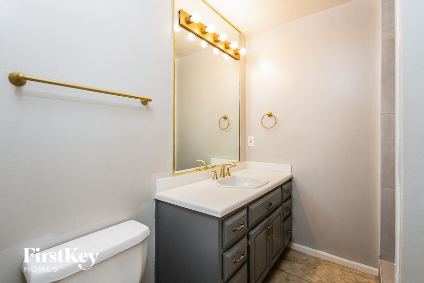 a bathroom with a toilet sink and a mirror