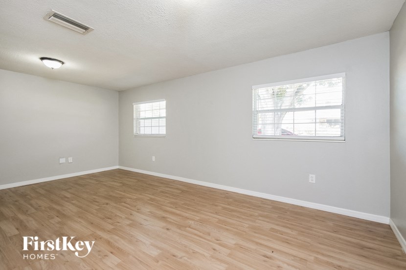 an empty living room with wood flooring and a window