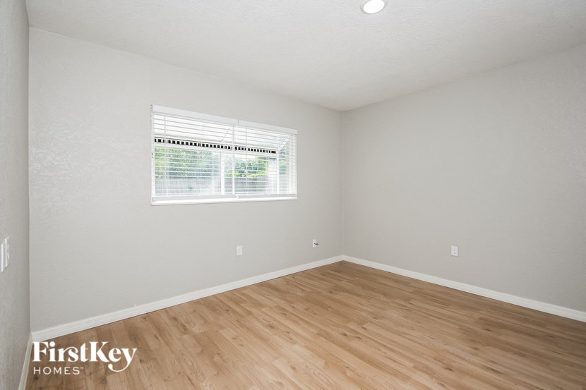 the living room of a home with wood flooring and a window