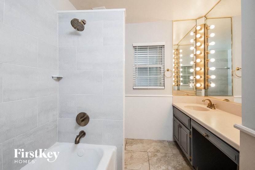 a bathroom with a tub and a sink and a mirror