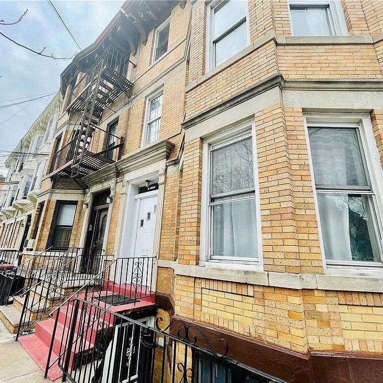 a brick building with a balcony and a white door