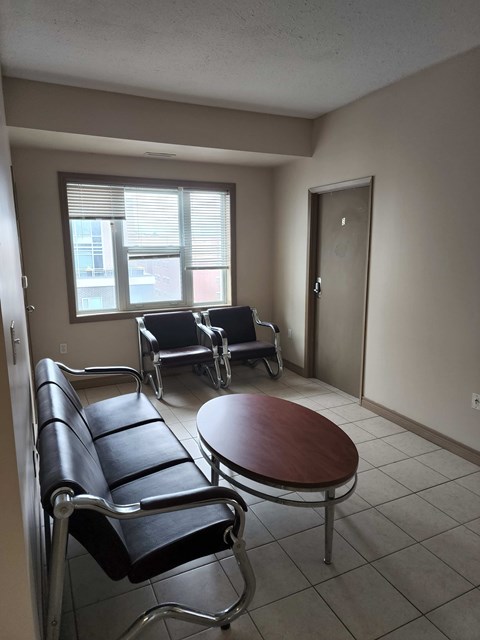 A waiting room with two chairs and a table.