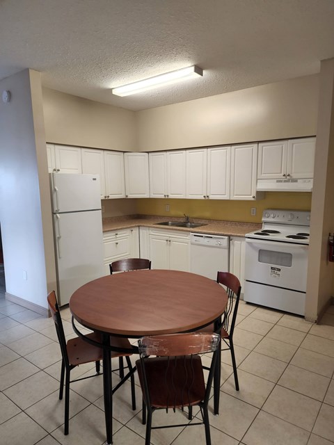 A kitchen with a table and chairs.