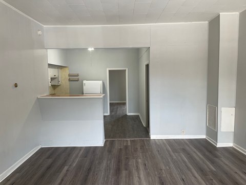 A room with a white wall and a grey floor.