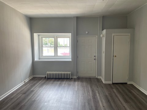 A room with a window, two doors, and a radiator.