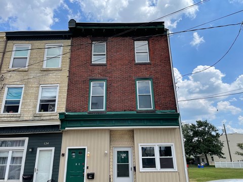 Three story building with red brick and green trim.