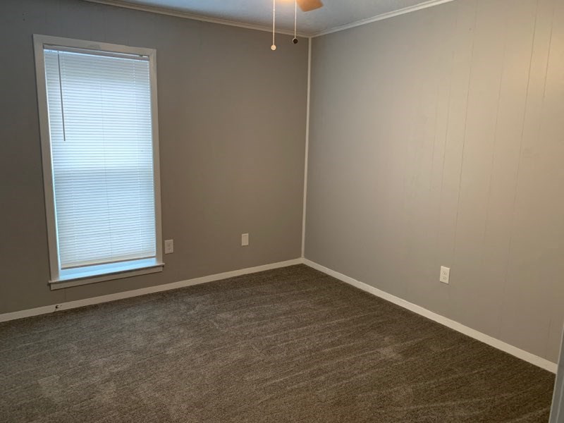 an empty room with a window and a carpet