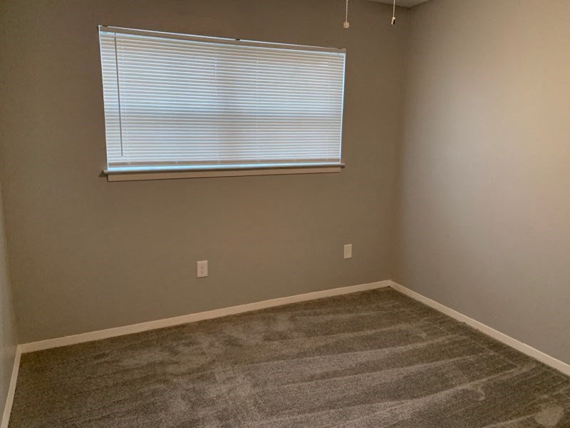 a empty room with a window and a carpet