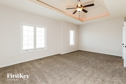 a living room with carpet and a ceiling fan