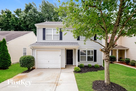 a white house with a tree in front of it