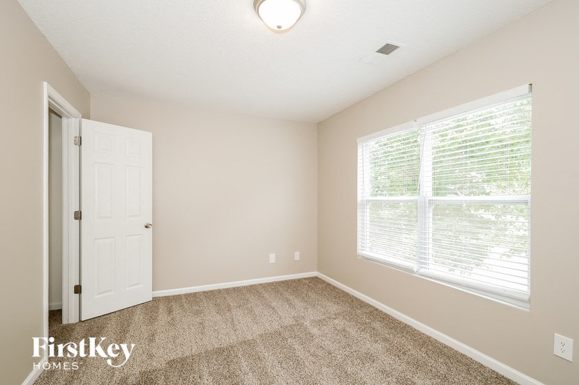 an empty room with a large window and a white door