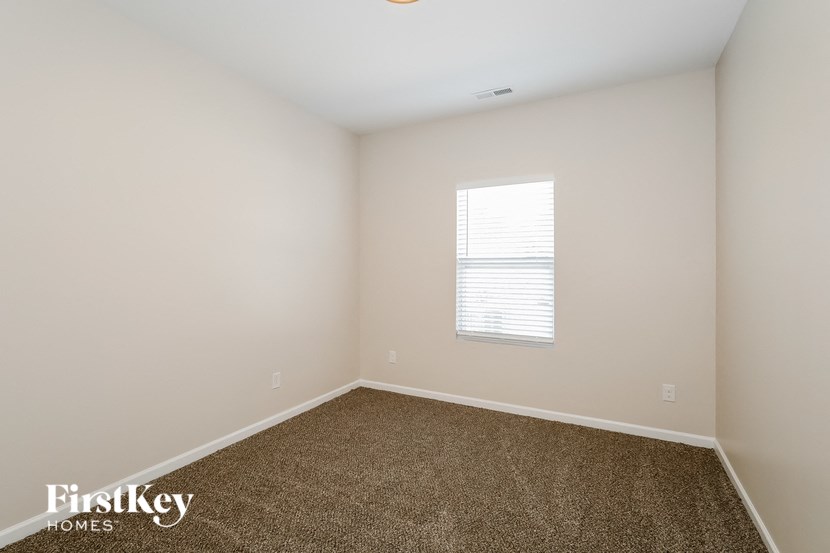 an empty room with carpet and a window