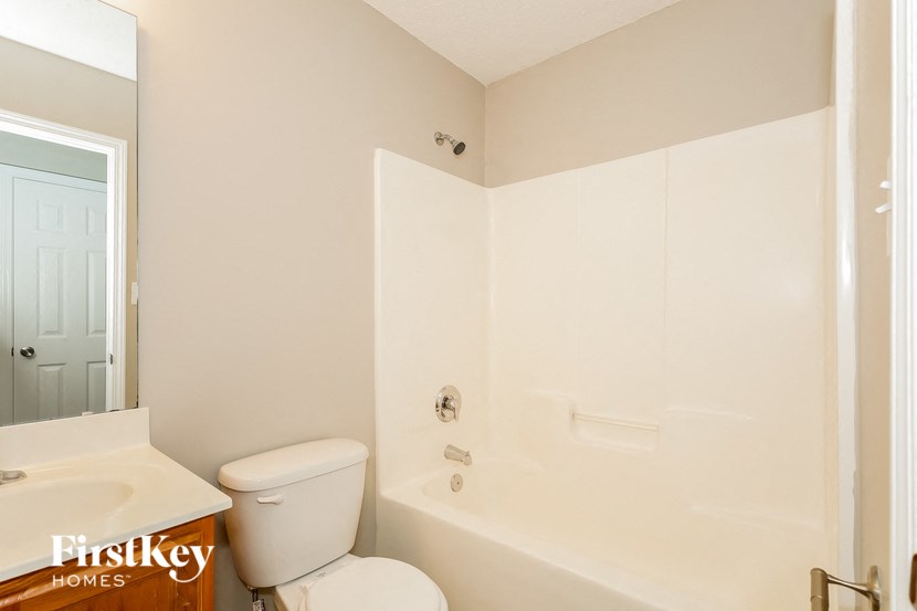 a bathroom with a toilet and a tub and a sink