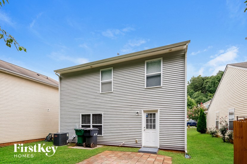 the front of a white house with a white door and a green yard