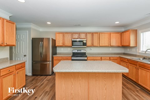 A kitchen with wooden cabinets and a granite countertop.