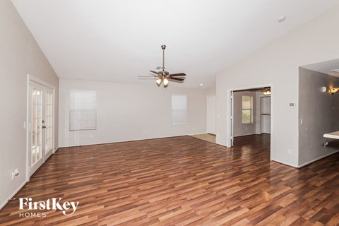 a living room with wood flooring and a ceiling fan