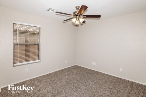 a bedroom with a ceiling fan and a window