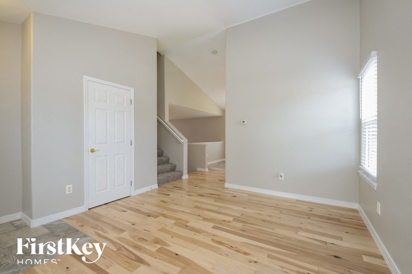 a renovated living room with hardwood floors and a white door