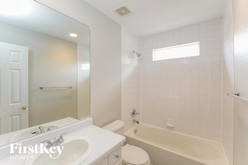 a white bathroom with a tub and a sink and a toilet