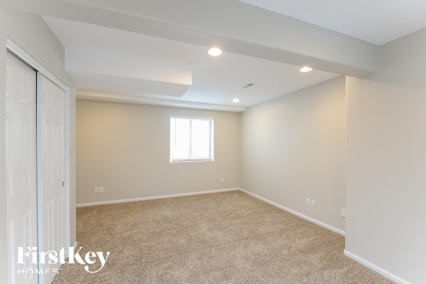 a bedroom with carpet and a closet and a window