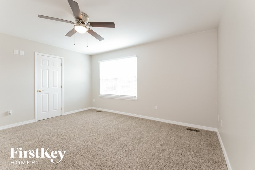 a empty room with a ceiling fan and a window
