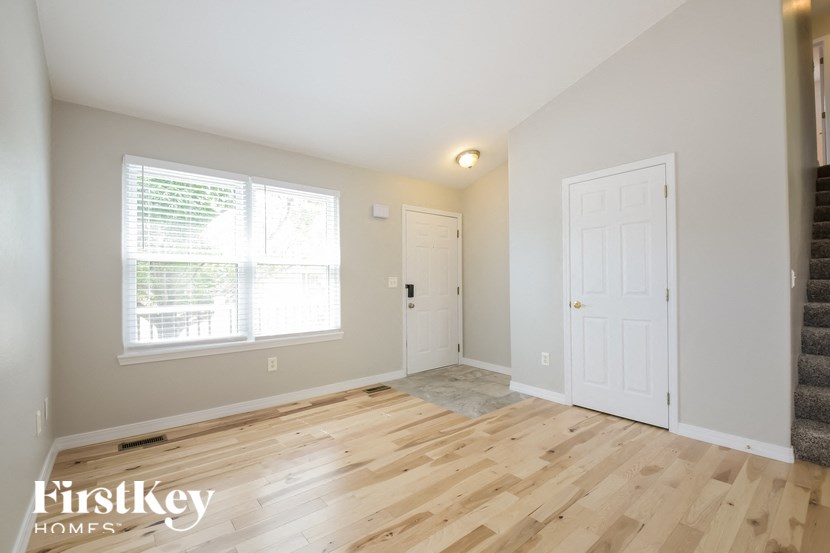 a living room with a wooden floor and a white door
