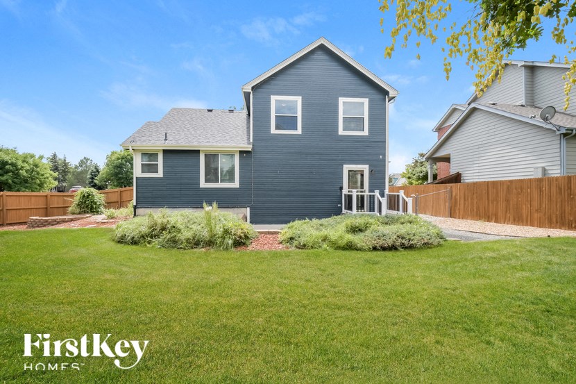 a blue house with a yard and a wooden fence