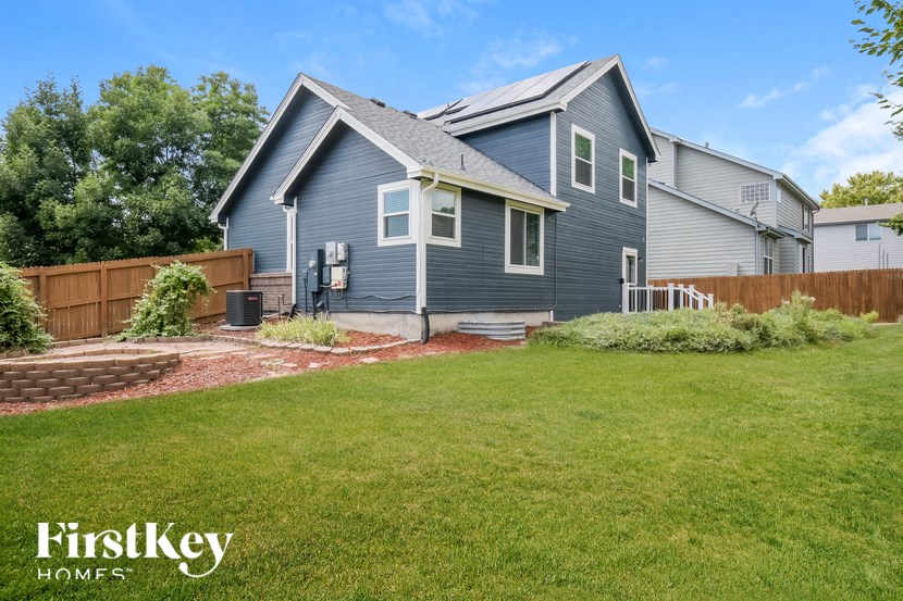 a blue house with a yard and a wooden fence