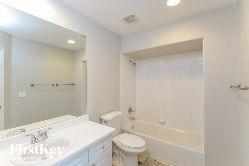 a white bathroom with a toilet and a tub and a sink