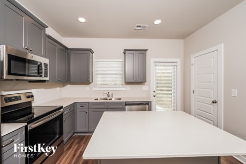 A kitchen with a white table and a FirstKey Homes logo.