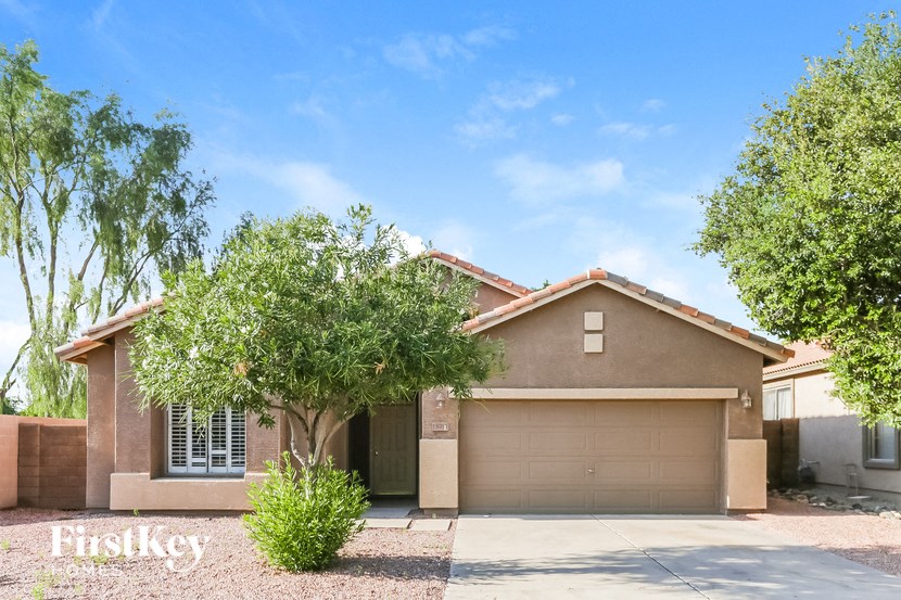 A house with a brown garage door and a tree in front.