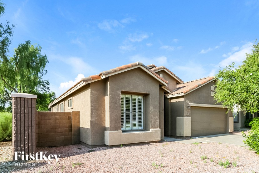 A house with a brown roof and a brown fence is shown.