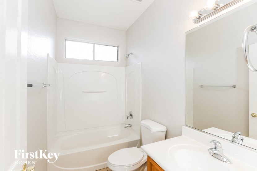 A white bathroom with a toilet, sink, and bathtub.